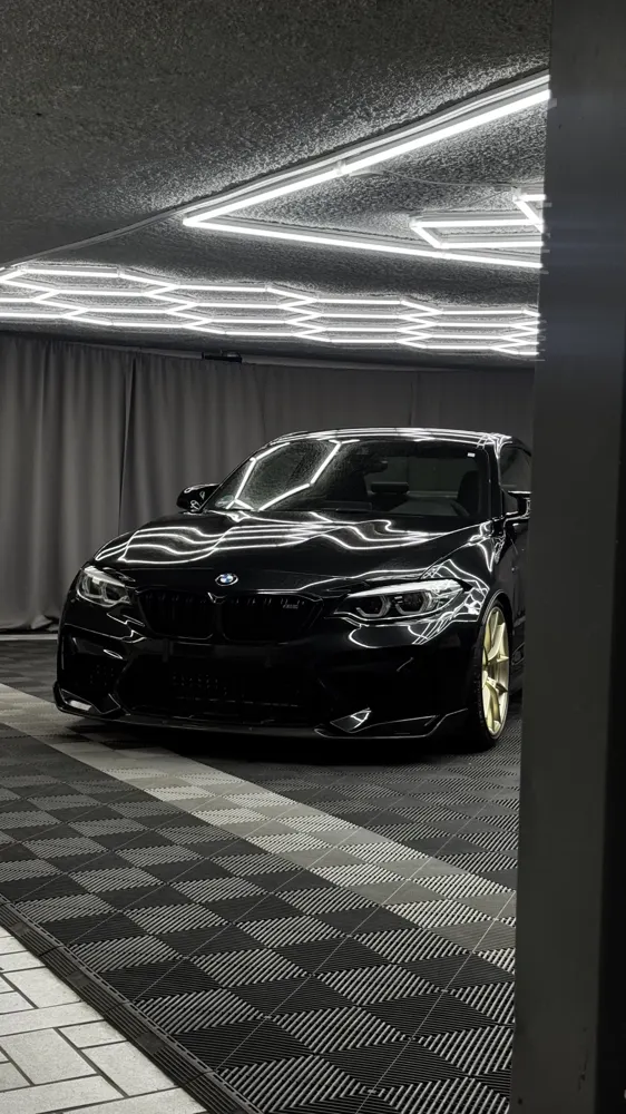 Schwarzer BMW mit goldenen Felgen in der LEVITÓ-Halle in München-Moosach